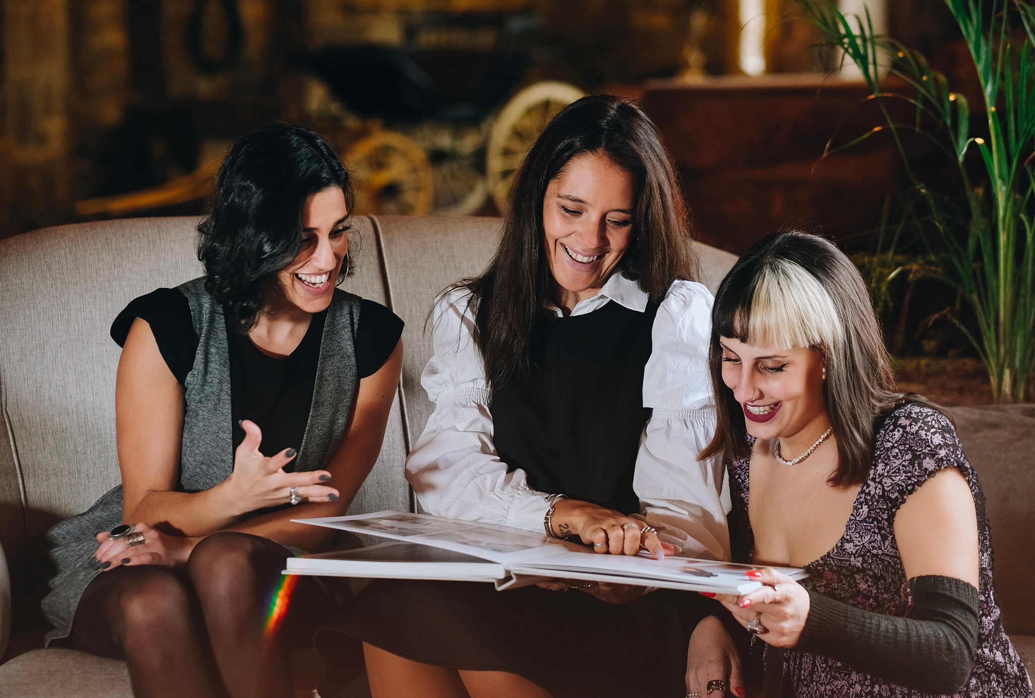 Trois amies feuilletent un album photo ensemble